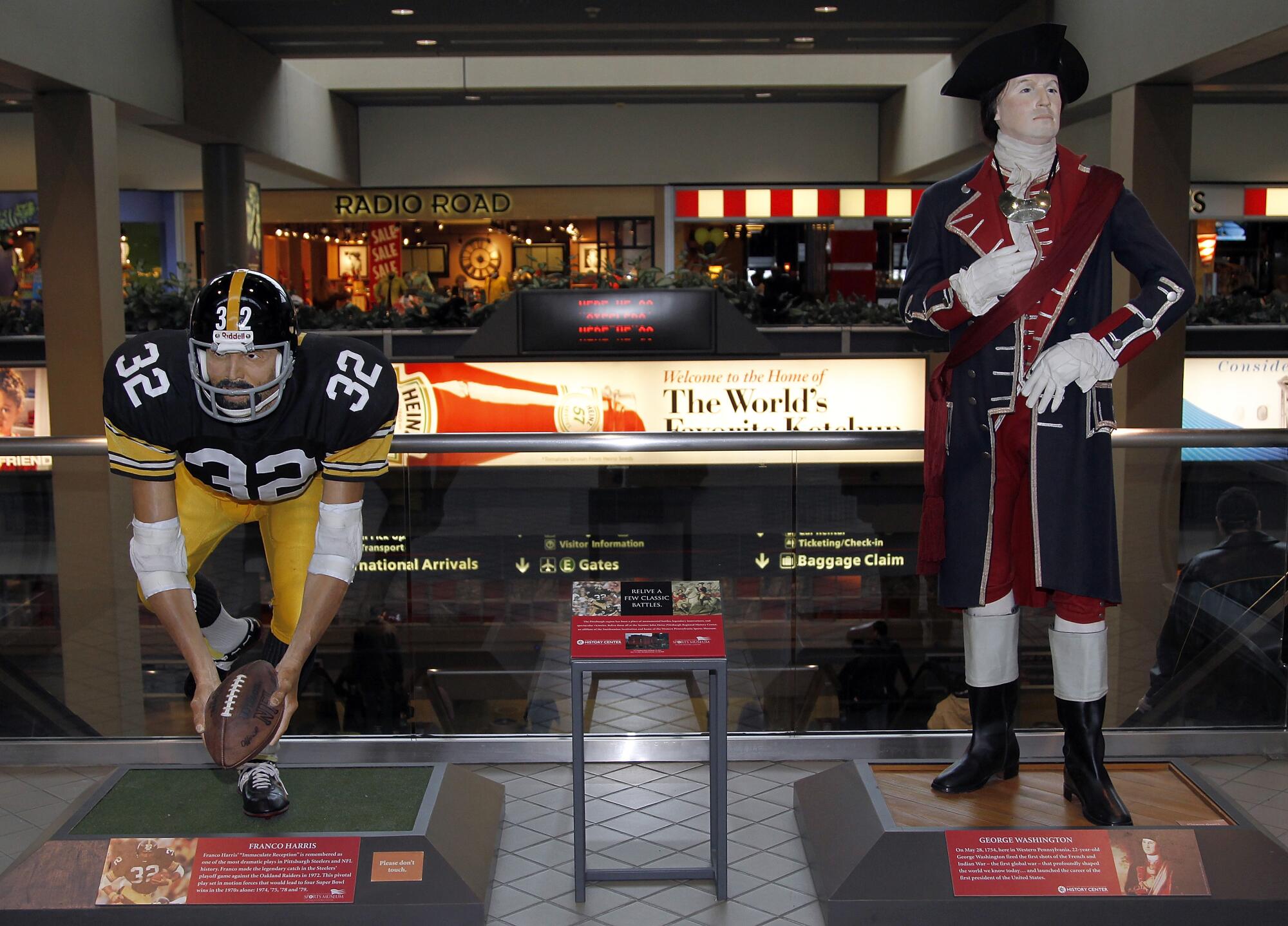 Statues of the Steelers' Franco Harris and George Washington, the first U.S. president, at Pittsburgh International Airport.