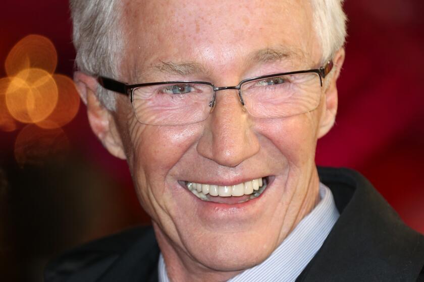 Paul O'Grady in a suit smiling