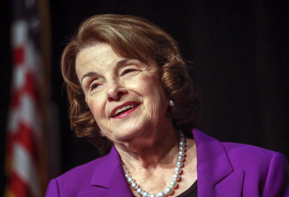 Sen. Dianne Feinstein in a purple jacket and pearl necklace.