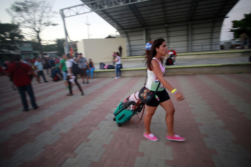 Una migrante cubana camina hacia un autobús fletado por el gobierno de Costa Rica que la llevará al aeropuerto de La Cruz, en Costa Rica,