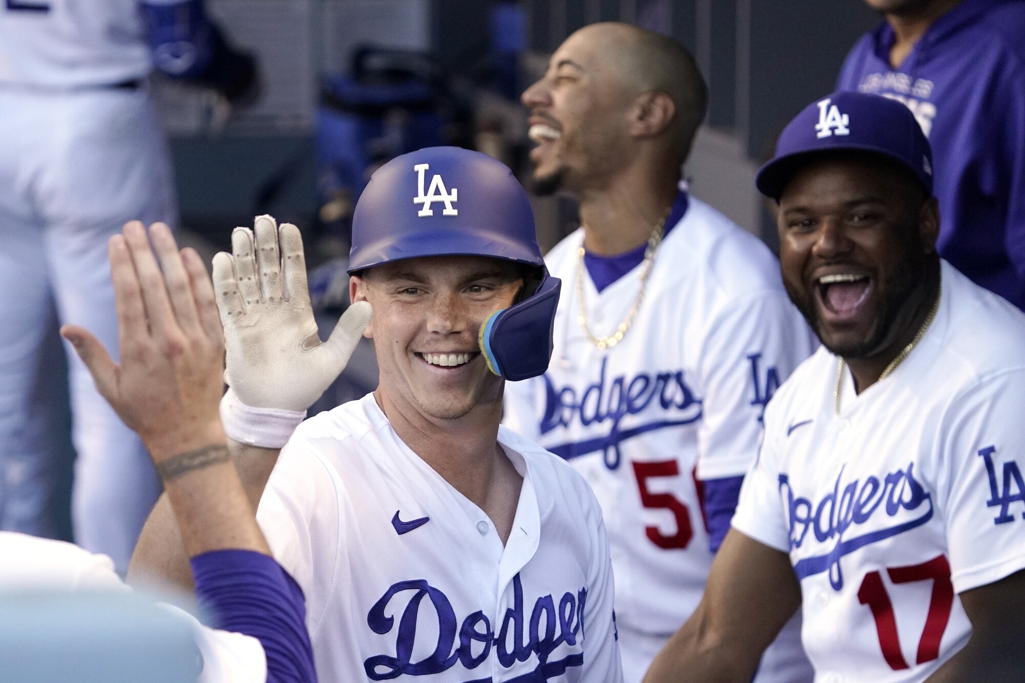 Dodgers catcher Will Smith is congratulated by teammates in the dugout after hitting a solo home run.