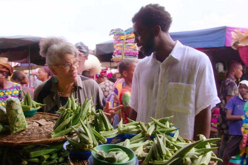 In the first episode of the new Netflix series, "High on the Hog: How African American Cuisine Transformed America," host Stephen Satterfield (right) explores a West African open-air market with historian and author Jessica B. Harris.