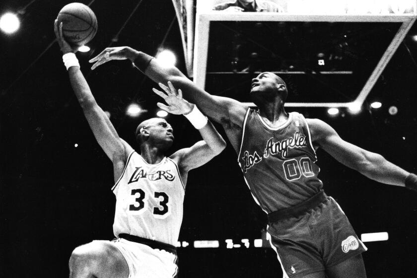 NOV. 12, 1987 – Kareem Abdul–Jabbar shoots a sky hook over Clipper Benoit Benjamin (00) in the Lakers' 111–82 win.