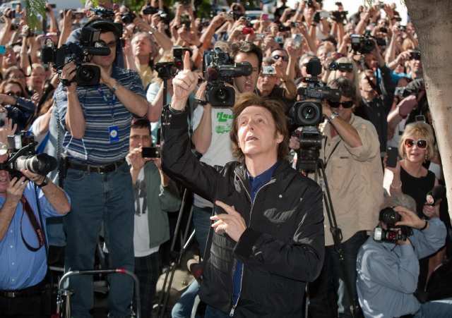 McCartney acknowledges the crowd, including those on the roof, as he arrives for his Hollywood Walk of Fame star dedication. View the scene 360°