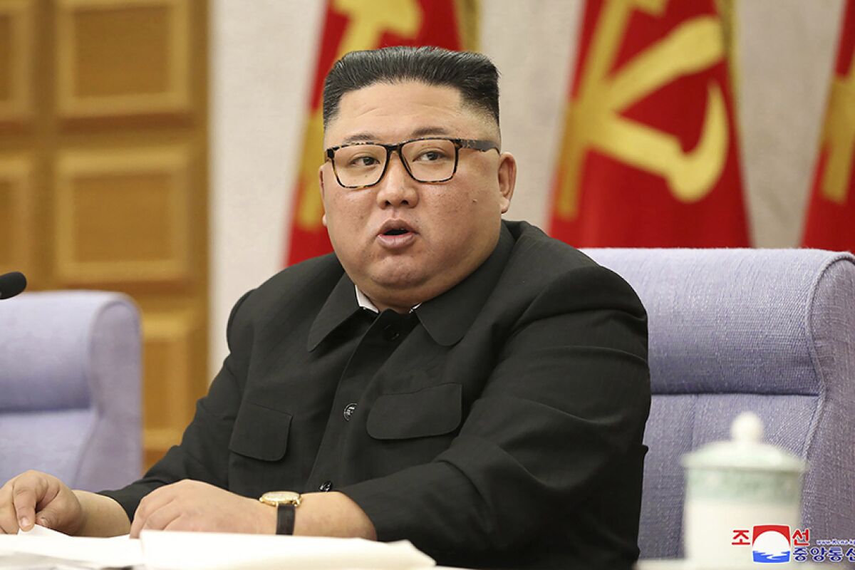Kim Jong Un sits at a table.