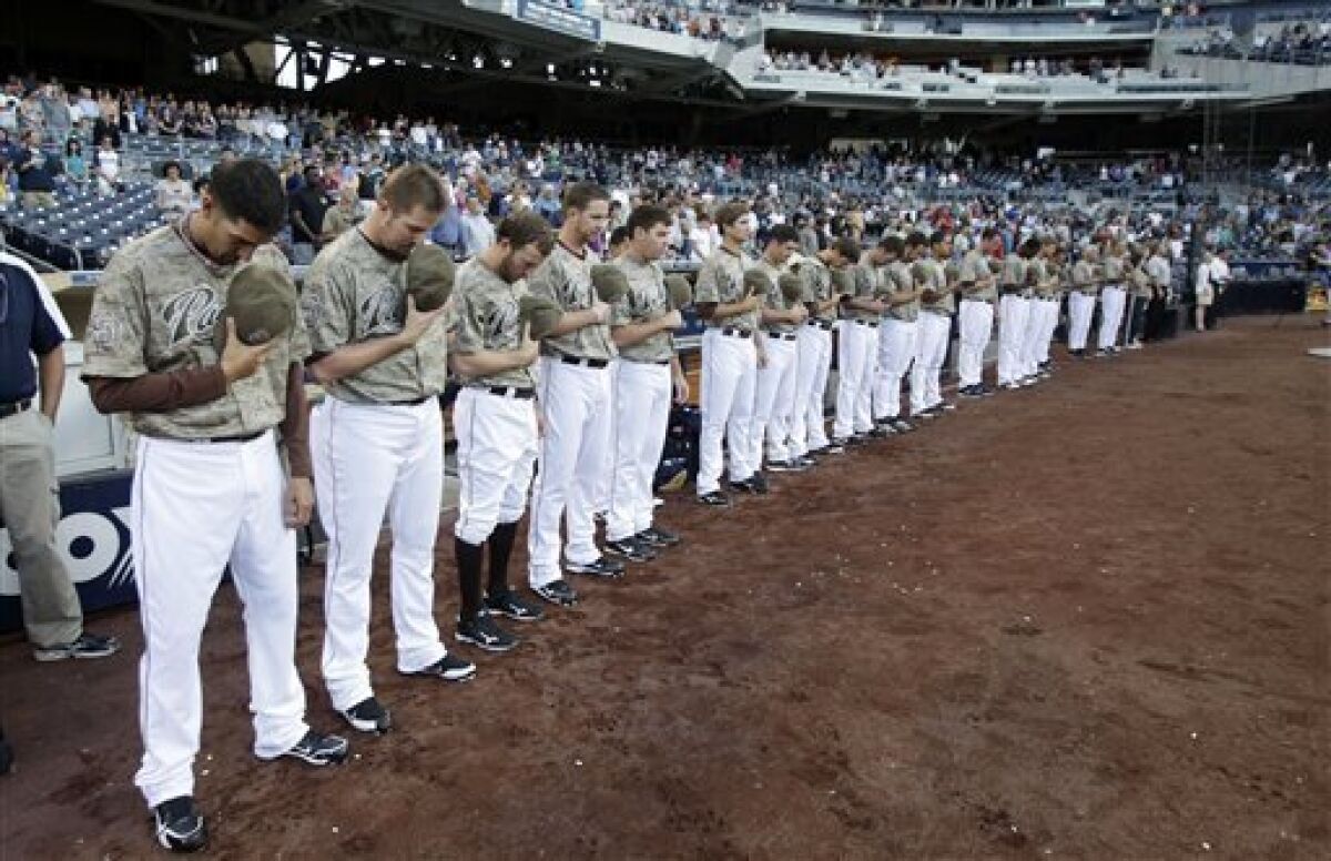Padres players bow their head in a moment of silence for the victims of the 9/11 terrorist attack prior to their baseball game against the Pittsburgh Pirates on Monday, May 2, 2011 in San Diego. The players requested to wear their camouflage uniforms that day. (AP Photo/Lenny Ignelzi)