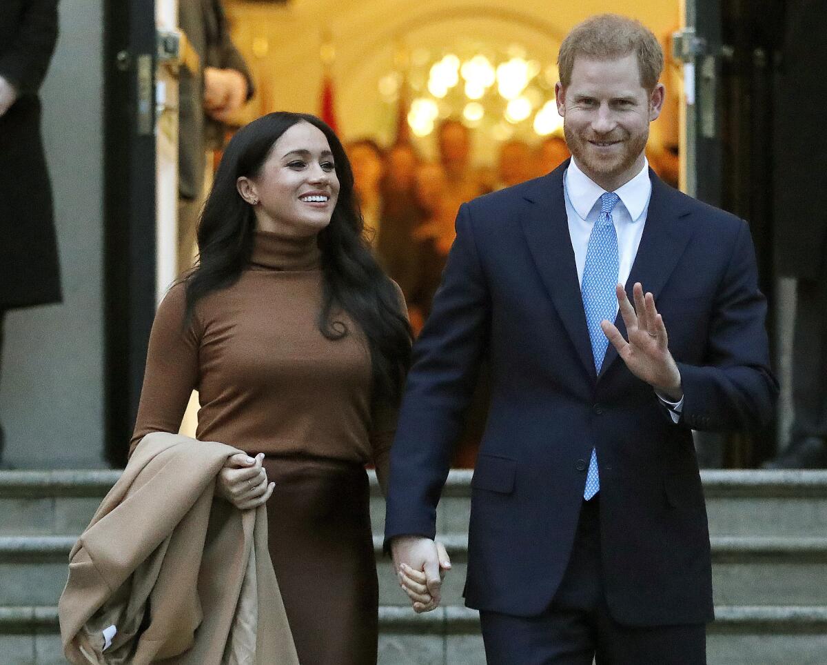 Meghan, Duchess of Sussex, walks with Prince Harry.