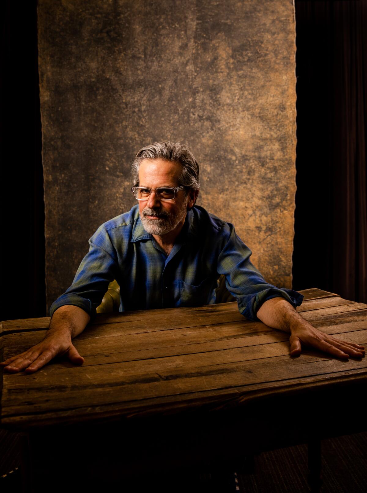 Jonathan Lethem sits behind a table and reaches his hands across it at the 2022 Los Angeles Times Festival of Books