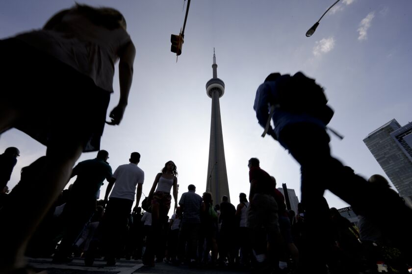People make their way towards the CN Tower and Rogers Centre for the opening ceremony in the Pan Am Games in Toronto, Friday, July 10, 2015. (AP Photo/Gregory Bull)