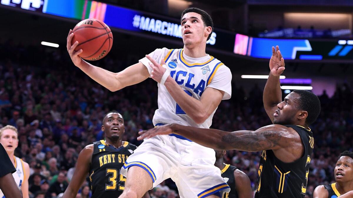 UCLA guard Lonzo Ball scores as he's fouled by Kent State forward Kevin Zabo during the first half Friday night.