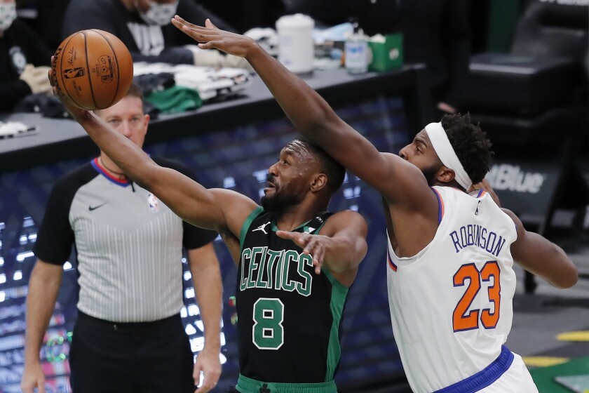 Boston Celtics' Kemba Walker (8) shoots against New York Knicks' Mitchell Robinson (23) during the first half of an NBA basketball game, Sunday, Jan. 17, 2021, in Boston. (AP Photo/Michael Dwyer)