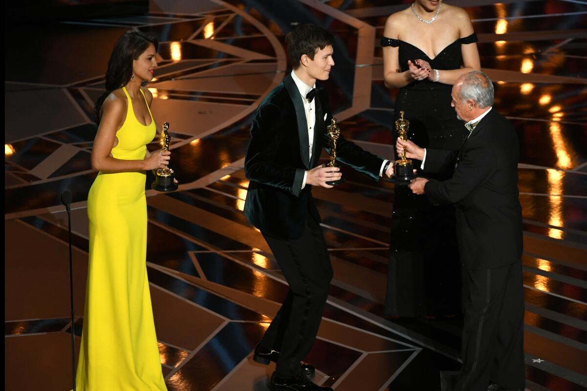 "Dunkirk" sound mixer Gregg Landaker, right, accepts the Oscar for sound mixing from actors Eiza Gonzalez, left, and Ansel Elgort at the 90th Academy Awards.