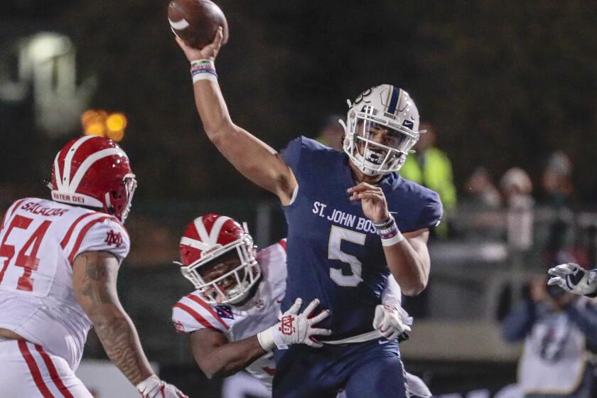 Mater Dei defenders pressure St. John Bosco quarterback DJ Uiagalalei during the Southern Section Division 1 championship game Nov. 30, 2019, at Cerritos College.