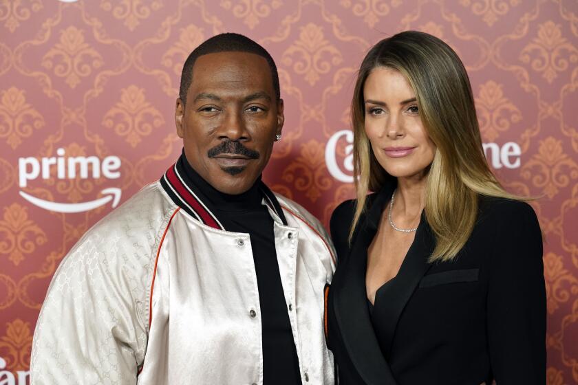Eddie Murphy and Paige Butcher pose at the premiere of "Candy Cane Lane" at the Regency Village Theatre