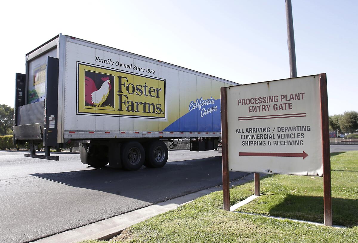 A truck with the Foster Farms logo outside a processing plant entry gate