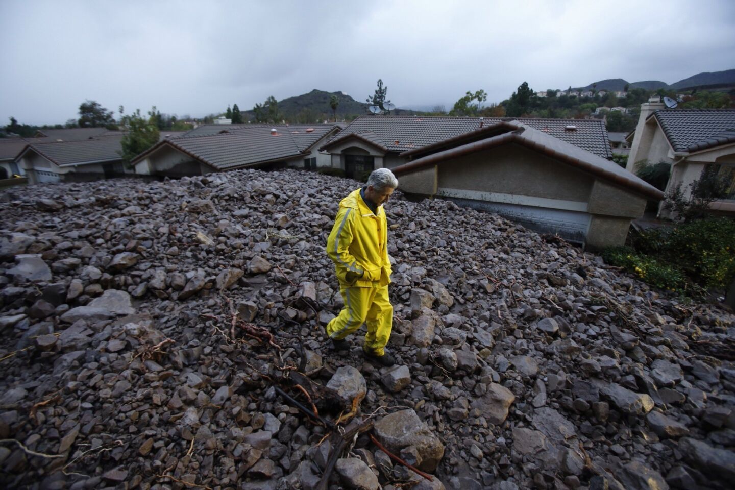 Ventura County Sheriff's deputy Guy Stewart surveys the cascade of mud and rock that covered Gitana Ave in Camarillo Springs Friday morning.