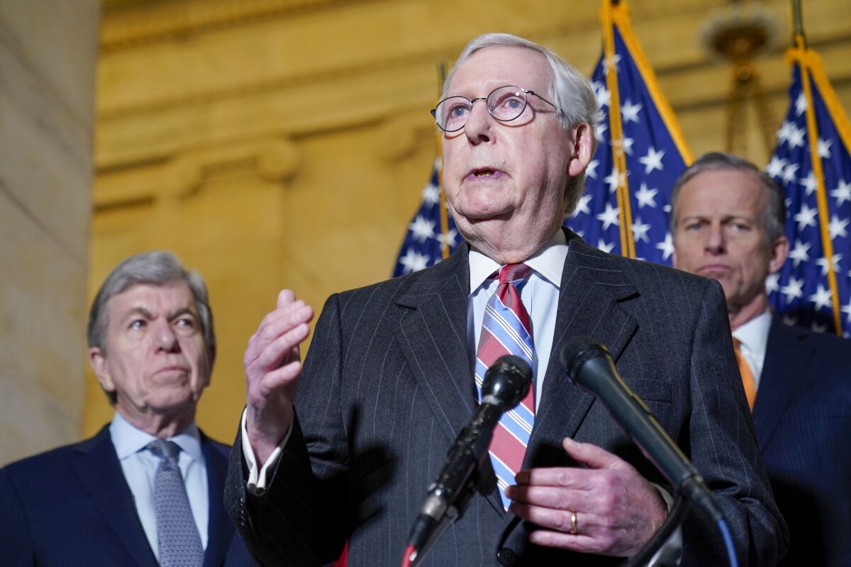 Senate Minority Leader Mitch McConnell of Ky., center, speaks to reporters on Capitol Hill in Washington, Tuesday, Feb. 8, 2022. Standing with McConnell is Sen. Roy Blunt, R-Mo., left, and Sen. John Thune, R-S.D., right. (AP Photo/Susan Walsh)