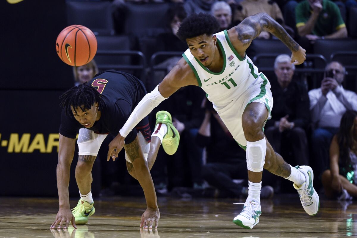 USC guard Boogie Ellis and Oregon guard Rivaldo Soares scramble after the ball during the second half.