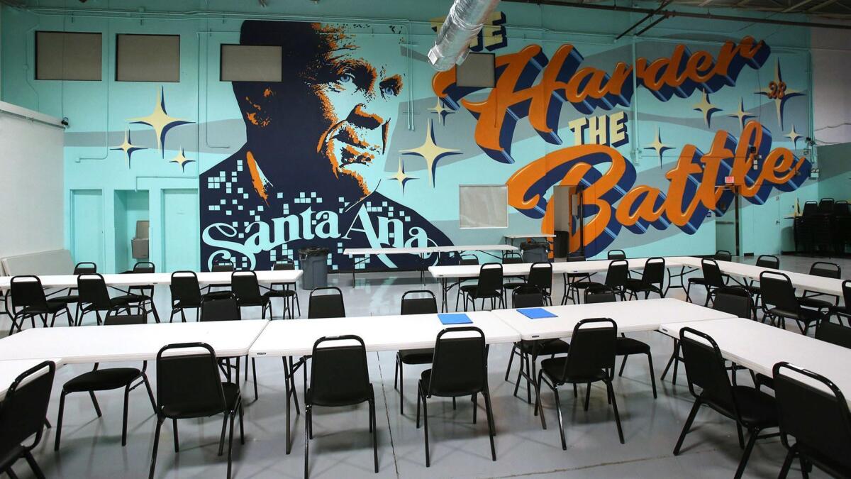 A wall-size mural of U.S. District Judge David O. Carter and the phrase “The harder the battle, the sweeter the victory” adorns the new interim homeless shelter wall in Santa Ana. “The Link” started admitting people Thursday night.