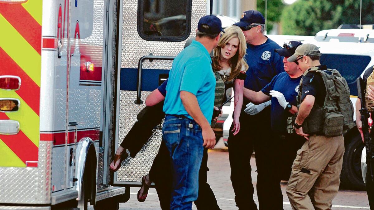 An injured woman is carried to an ambulance in Clovis, N.M., after a shooting in a public library on Monday.