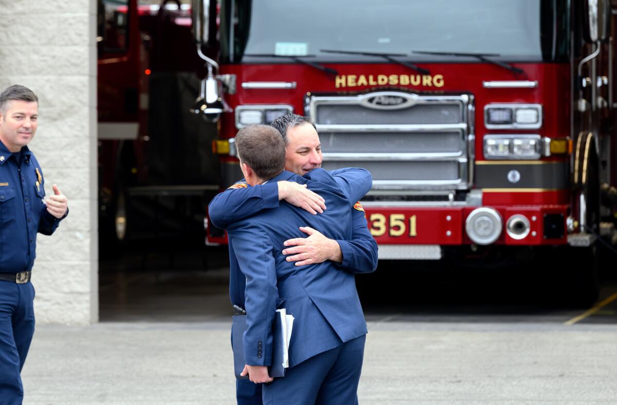 加州参议员迈克·麦奎尔拥抱一名消防员 