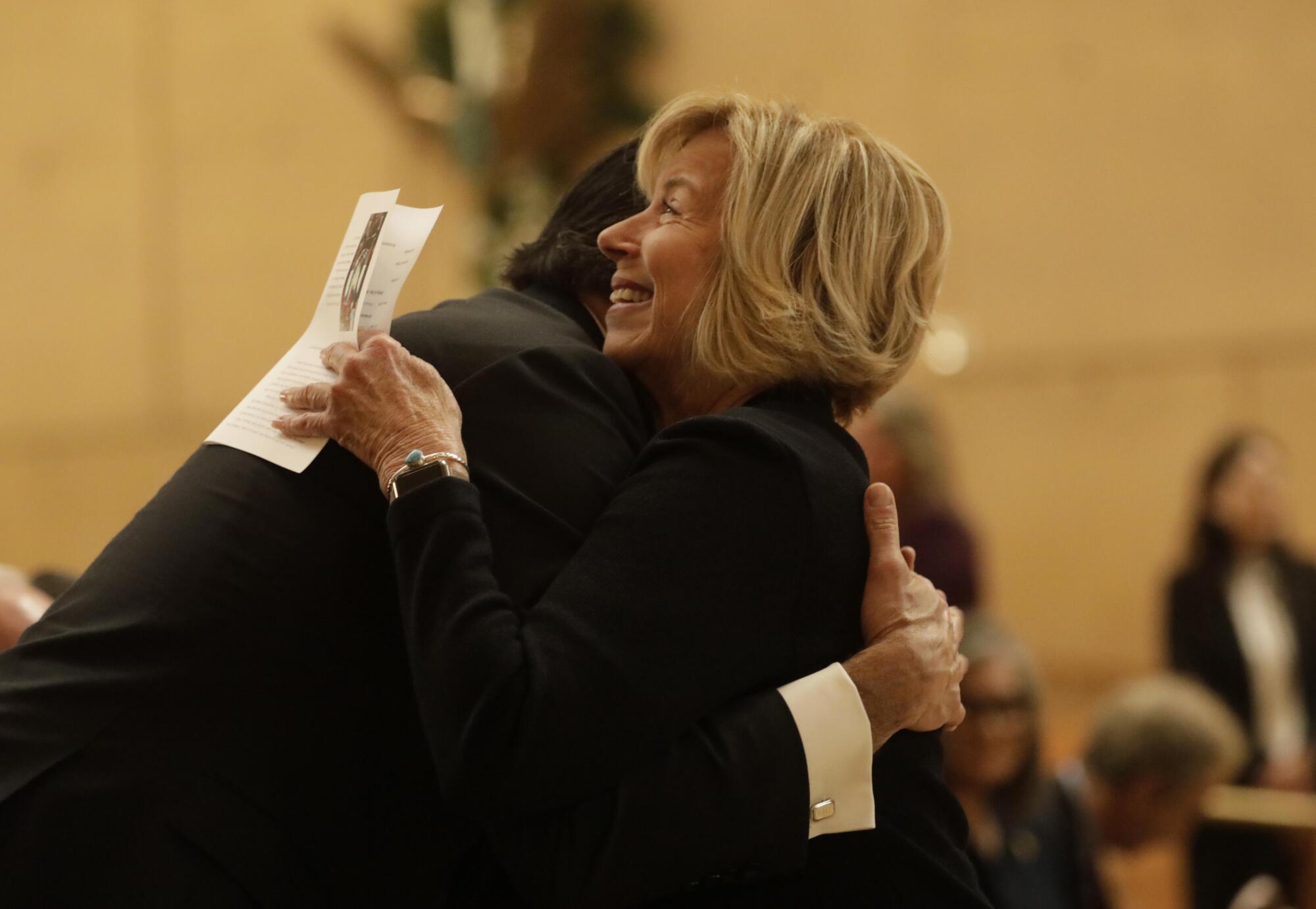 Los Angeles County Supervisor Janice Hahn hugs former City Atty. Rocky Delgadillo before the memorial Mass.