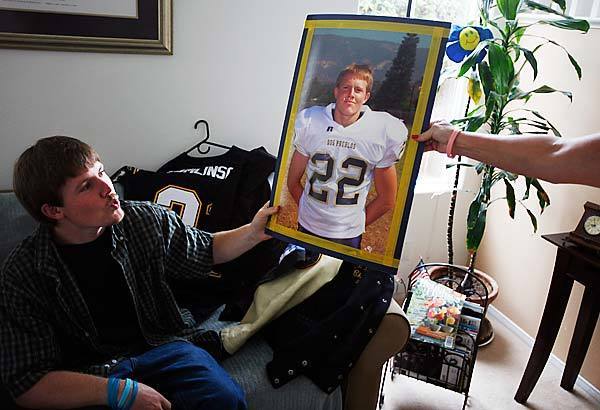 Brad Ebner, who suffered a traumatic brain injury while playing tailback for Goleta Dos Pueblos High in 2006, is handed a photo from his playing days. Bradley was in a coma for eight days and has had a long road to physical and mental rehabilitation.