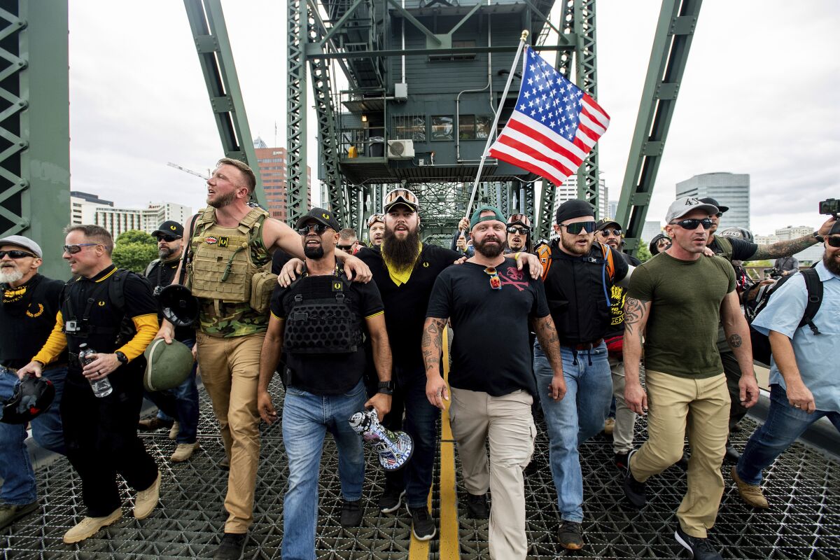 Men march across a metal bridge.