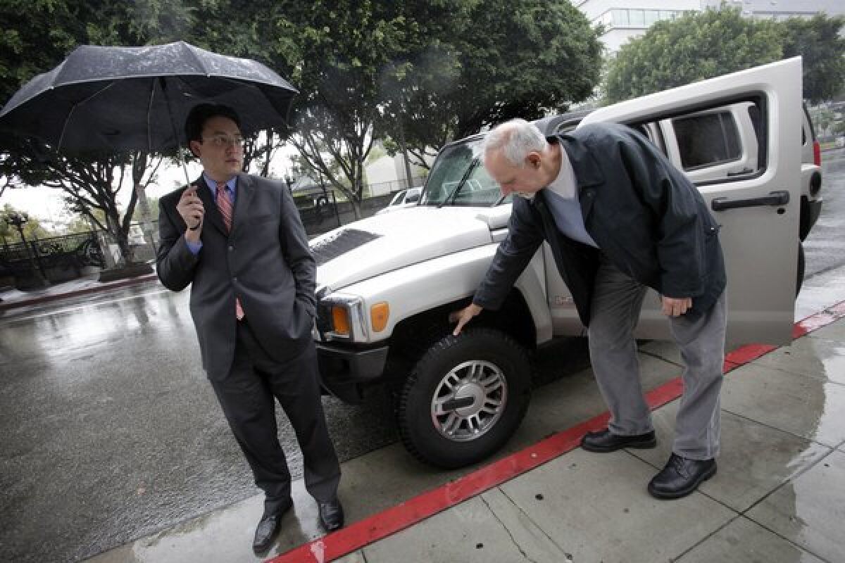 L.A. Times columnist Steve Lopez, right, checks the tires of Deputy Mayor Jaime De La Vega's Hummer in February 2010.