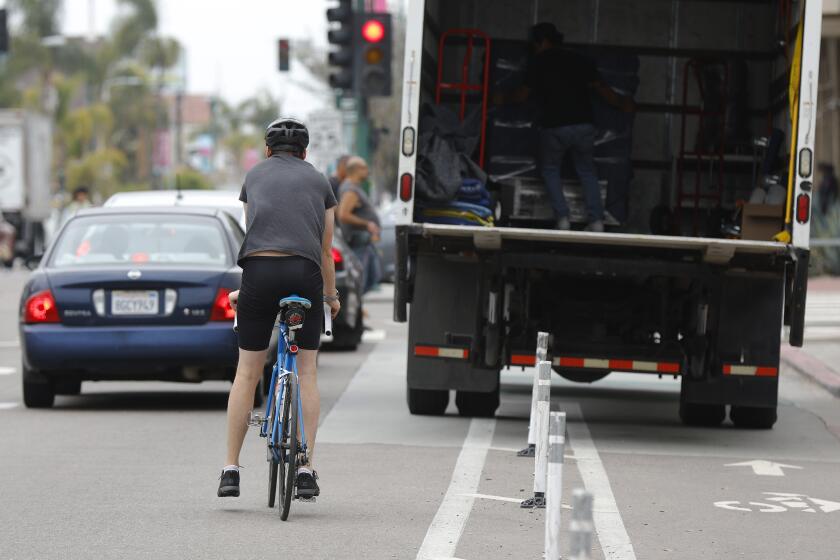 San Diego CA - May 2: A cyclist navigates around a box truck parked in the bike lane on 30th Street in North Park on Thursday, May 2, 2024. (K.C. Alfred / The San Diego Union-Tribune)