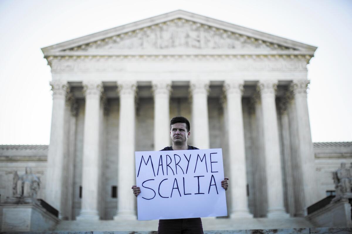 Ryan Aquilina of Washington, D.C., a supporter of same-sex marriage, demonstrates near the Supreme Court on April 28. The court has decided same-sex couples have a right to marry nationwide.