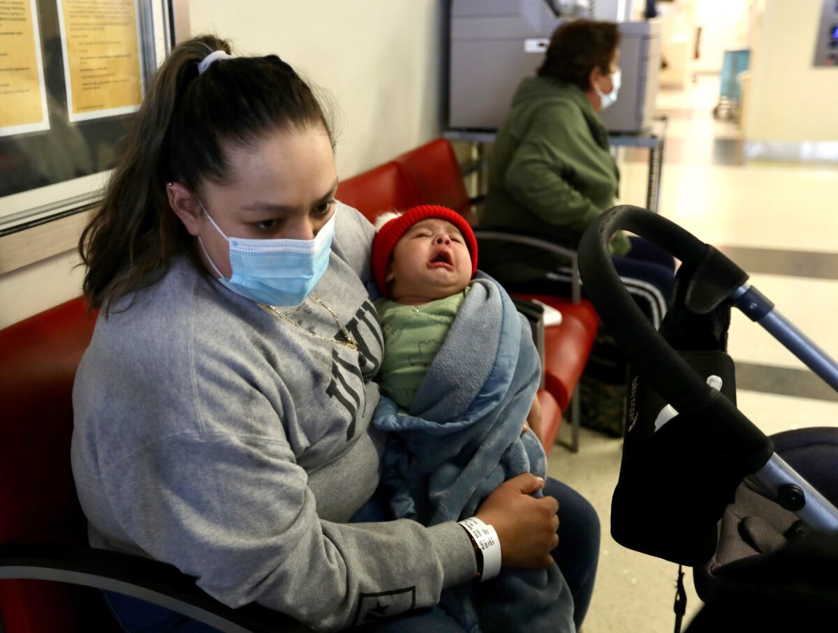 A woman sits with her son at a hospital.