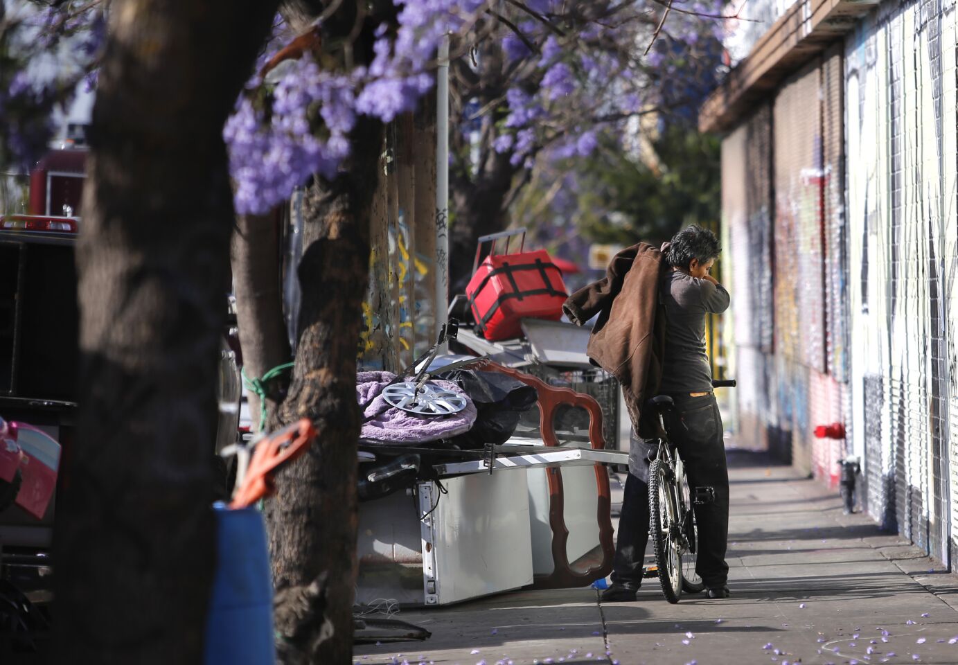 A homeless man secures his belongings before riding away on his bike in Los Angeles.