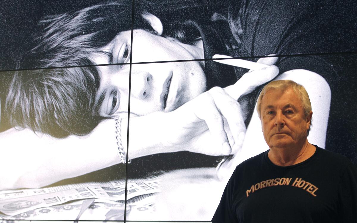 Terry O'Neill poses in front of his picture of Mick Jagger during a 2013 exhibition of O'Neill's work in Madrid.