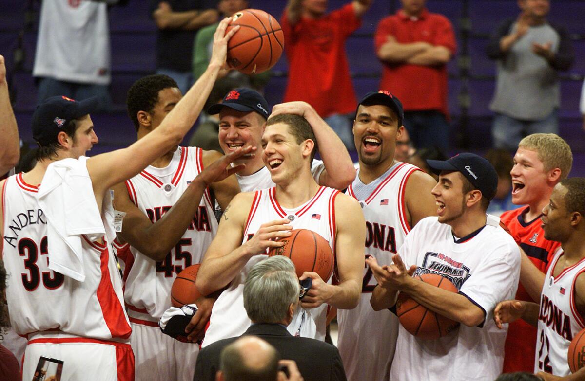 Arizona players mob Luke Walton after he comes on to the podium after the Wildcats beat USC in the Pac-10 championship game at Staples Center on Mar. 9, 2002.