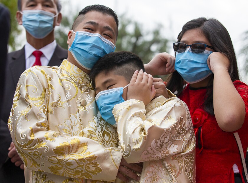 Parishioners plug their ears as firecrackers go off during a mass at the Vietnamese Catholic Center in Santa Ana.