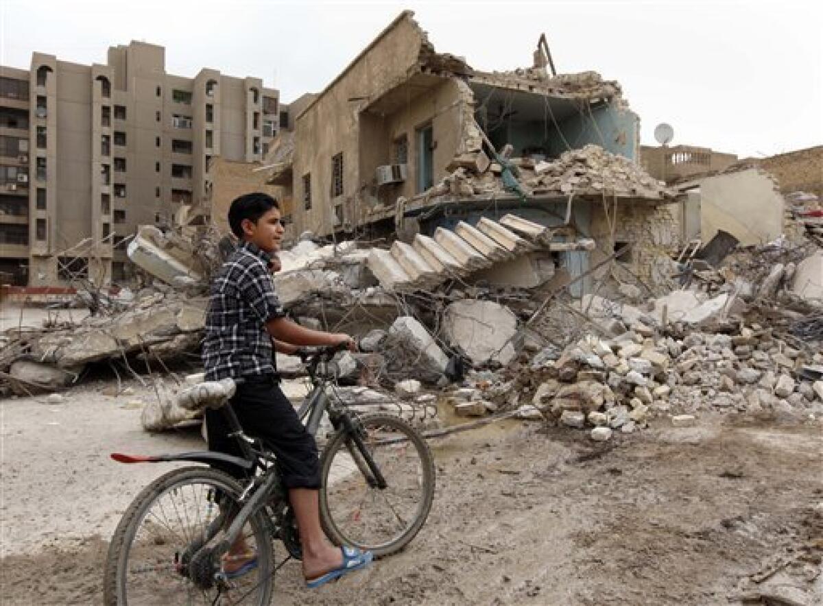 An boy inspects the scene of a bomb attack in Baghdad, Iraq, Wednesday, April 7, 2010. At least seven bombs ripped through apartment buildings across Baghdad on Tuesday and another struck a market. (AP Photo/Hadi Mizban)
