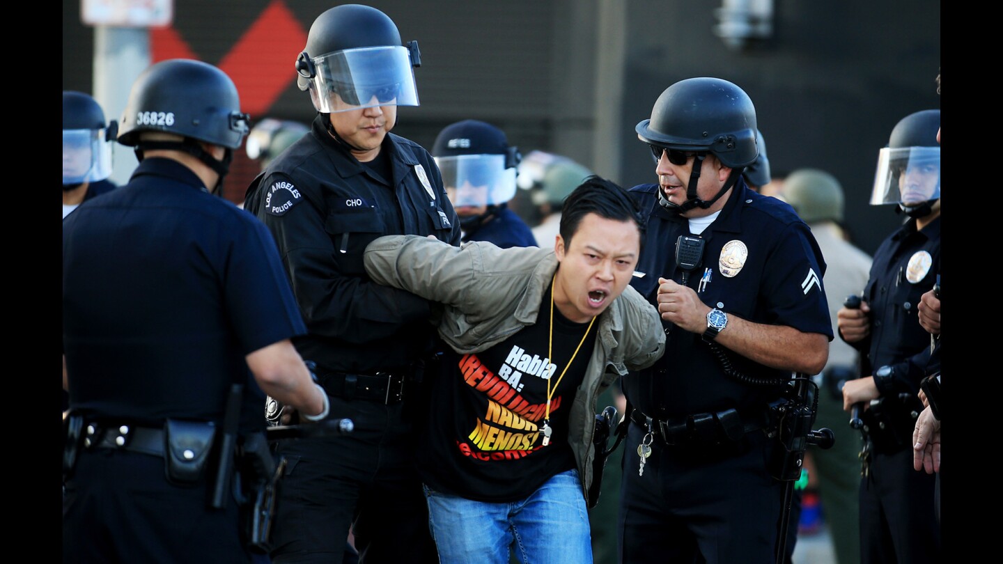 LAPD officers arrest one of about a dozen anti-police brutality protesters blocking the intersection of Washington Boulevard and Main Street in downtown Los Angeles on Tuesday, April 14, 2015.