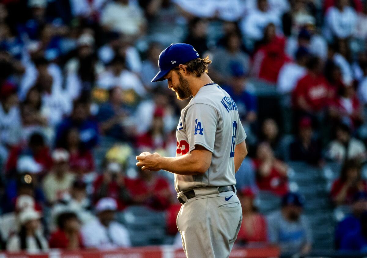 Clayton Kershaw stares down at the ball before throwing his first pitch.