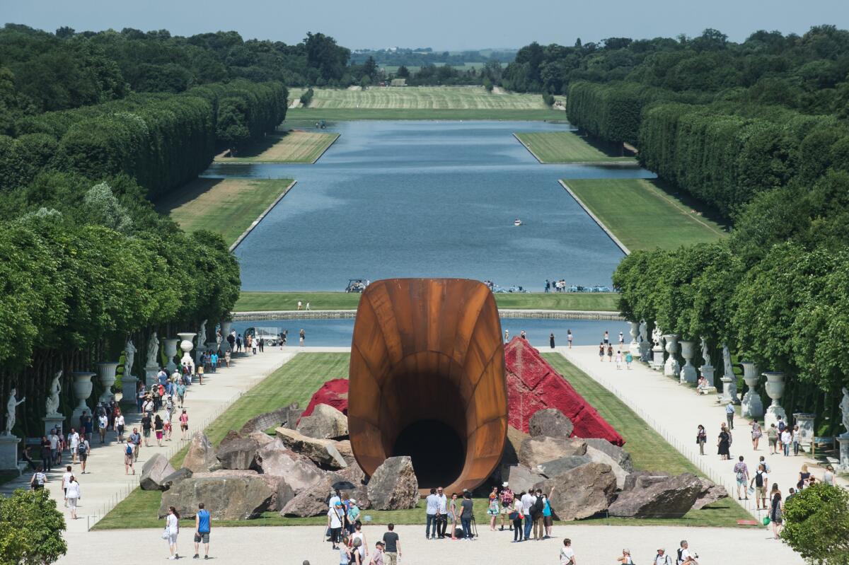 Visitors walk alongside 'Dirty Corners' by British artist Anish Kapoor in the gardens of the Chateau de Versailles outside Paris. The new piece has generated controvsery for its bodily connotations.