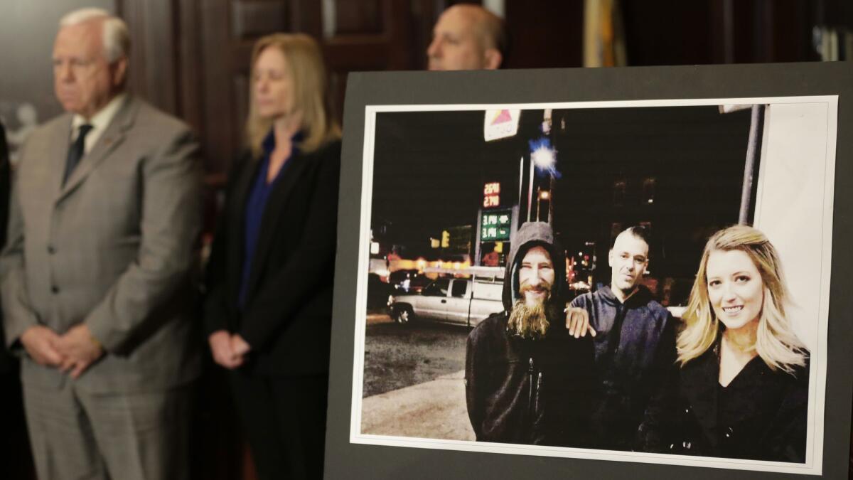 A picture of Katelyn McClure, right, Mark D'Amico, center, and Johnny Bobbitt is displayed during a news conference in Mt. Holly, N.J., on Thursday.
