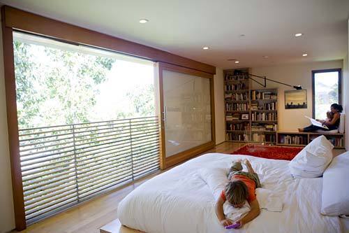 Rachel Klauber-Speiden reads to her children in a window alcove of the master bedroom. The former book editor shocked her architects by requesting 100 feet of bookshelves. "Books are really hard to throw away," she says. "The only things the kids have in their rooms are books and a bed." Yet another sliding door lets in light and air. It also provides views of the Getty Center. Full gallery