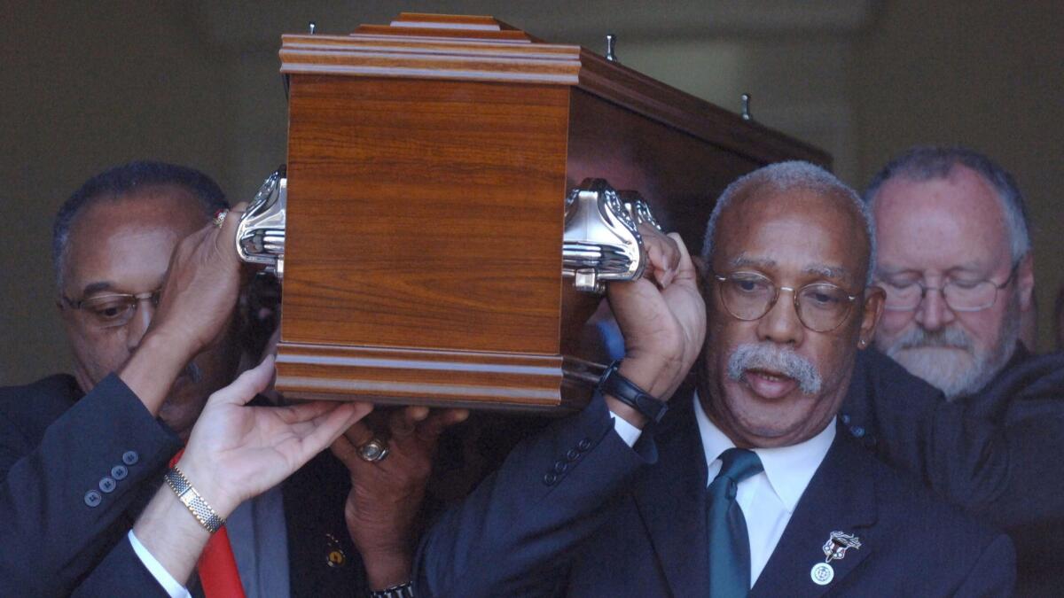 Tommie Smith, left, and John Carlos, center, who gave the historic black power salutes at the 1968 Olympics, carry the coffin of the third man on the podium, Peter Norman.
