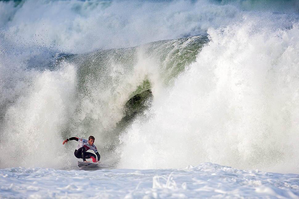 Kai Otton of Sydney, Australia, escapes through the "doggy door" of an 8-foot wave during the Quiksilver Pro France surfing competition.