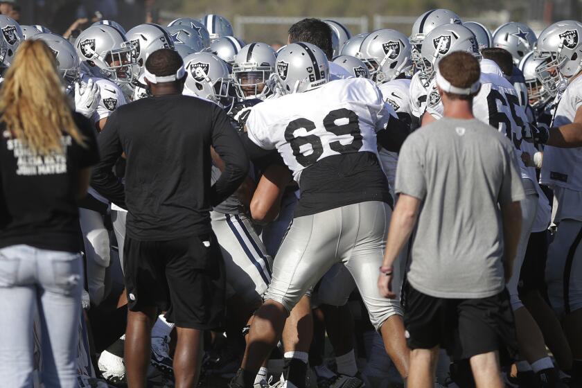 Oakland Raiders and Dallas Cowboys players scuffle during a joint football practice in Oxnard on Tuesday.