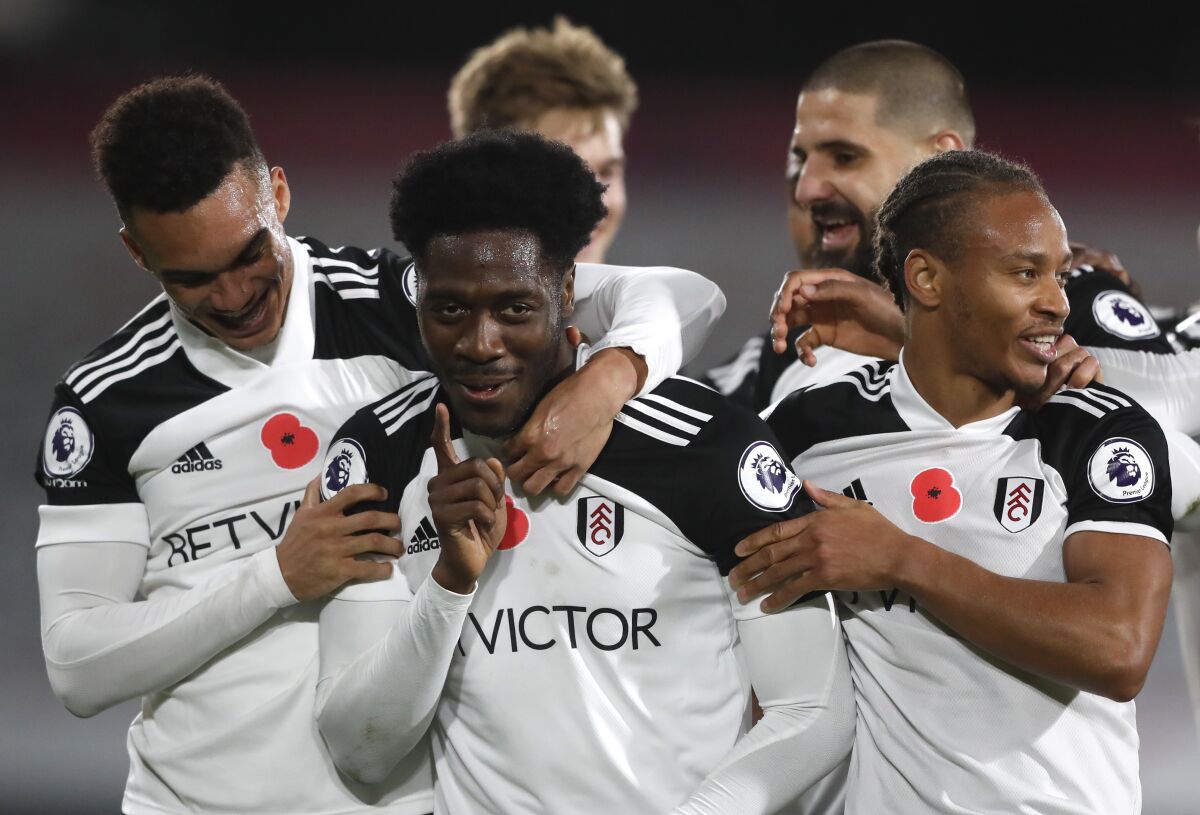 Fulham's Ola Aina, centre, celebrates after scoring his side's second goal during the English Premier League soccer match between Fulham and West Bromwich Albion at Craven Cottage in London, England, Monday, Nov. 2, 2020. (AP Photo/Frank Augstein, Pool)