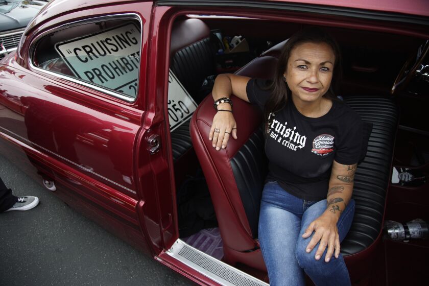 San Diego, California - May 19: Marisa Rosales, founding member of the United Lowrider Coalition sits in her lowrider in the back seat is the remove street sign that reads "Cruising Prohibited." Members of the United Lowrider Coalition celebrate in National City on Friday, May 19, 2023 in San Diego, California. (Alejandro Tamayo / The San Diego Union-Tribune)