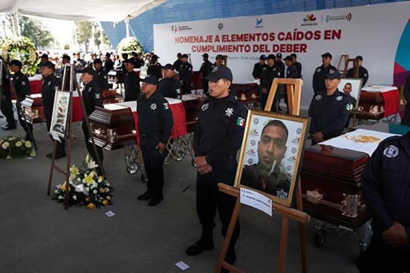 Agentes de la policía estatal de Michoacán junto a los ataúdes de sus colegas durante un funeral en la sede de la Secretaría de Seguridad Pública, en Morelia, México.