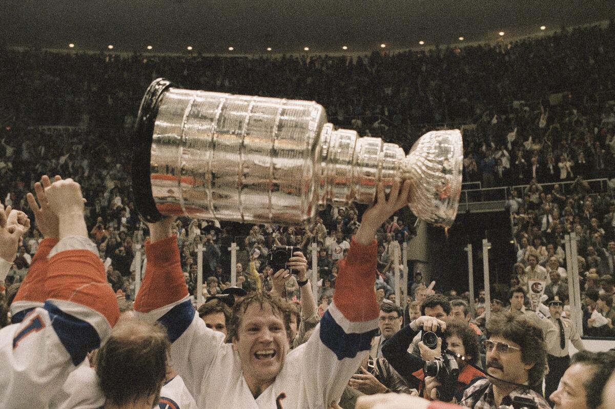 New York Islanders captain Denis Potvin holds the Stanley Cup after a victory over the Edmonton Oilers.