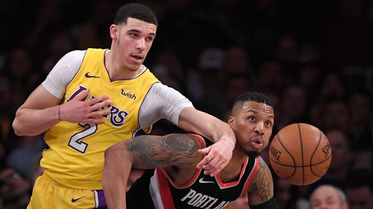 Lakers' Lonzo Ball, left, and Portland's Damian Lillard go after a loose ball on March 5 at Staples Center.